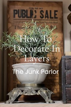 a potted plant sitting on top of a table next to a wooden box with the words how to decorate in layers