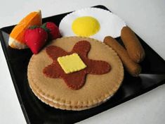 a black plate topped with food on top of a table