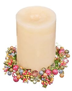 a candle with ornaments around it on a white background