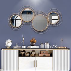 a white cabinet sitting under a mirror on top of a wall next to a dresser