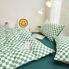 a green and white checkered bedspread on a bed with two laptops