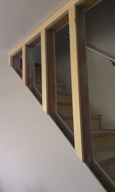 an empty room with unfinished walls and wooden steps leading up to the second floor area