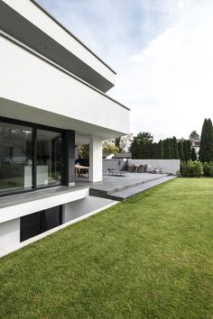 the back side of a modern house with grass