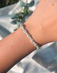 This beaded daisy bracelet is hand-woven using miyuki seed beads. This bracelet features white daisies, white round beads, and sage green beads in between with a silver accent center bead and sterling silver hardware (clasp & jump rings).  𝓂𝒶𝓉𝑒𝓇𝒾𝒶𝓁𝓈 ❁ Clasp and Jump rings:  Sterling Silver (clasp and Jump rings) ❁ High-Quality 3mm Japanese Seed Beads ❁ Monofilament Cord (non-stretch) Silver Seed Bead Bracelets, White Dainty Crystal Jubilee Bracelet, White Dainty Jubilee Crystal Bracelet, Delicate White Bracelets For Spring, White Delicate Bracelet For Spring, Delicate White Bracelet For Spring, White Delicate Beaded Bracelet, Minimalist White Jewelry For Spring, Delicate White Adjustable Crystal Bracelet