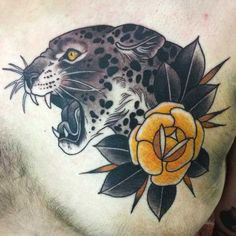 a man's chest with a leopard and flower tattoo on it