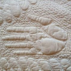 an old quilted hand and foot pattern on the back of a bed coverlet