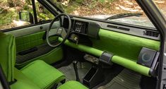 the interior of an old car with green leather seats and dash board, steering wheel and dashboard