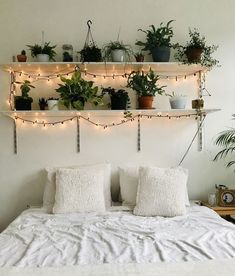 a white bed topped with lots of plants and lights