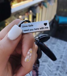 someone is holding up a fake ring that says drive safe, i need you here with me