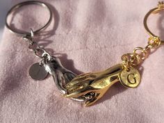 a close up of a key chain on a pink towel with a gold charm and two charms