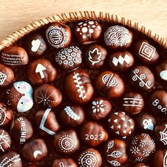 a basket filled with lots of chocolate eggs covered in different designs and shapes on top of a wooden table