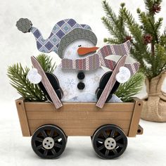 a snowman in a wagon with pine branches