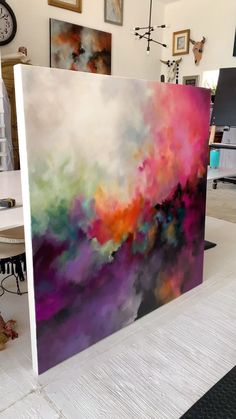 an abstract painting is displayed on a table