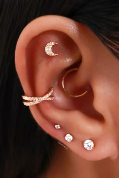 an ear with three different types of piercings