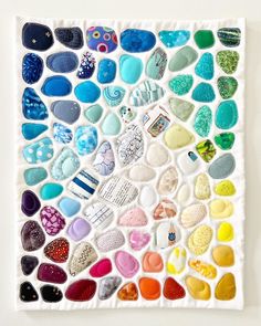 an art piece made out of different types of rocks and stones on a white surface