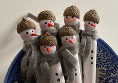 three snowmen are standing on toothbrushes in front of a plate