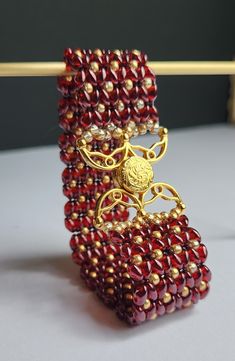 Gold lustered rich Siam ruby Superduo Czech glass beads are combined with gold Miyuki glass seed beads and a intricately beautiful Volkas III 24k gold plated magnetic clasp to create this stunning piece. The colours and design of this bracelet scream old world decadence and will definitely be make a glamourous addition to any outfit.  Dimension: 175mm x 26mm To keep your item in the best condition possible, we recommend avoiding exposure to water, harsh chemicals or perfume. To keep clean, gently wipe with a soft cloth and store either in provided box or a cool, dry location. To clean clasp or metallic accents, use included tarnish cloth.   Photographs have been minimally altered to genuinely reflect accurate item colouring. However, each devices screen may reflect colours slightly differe Super Duo, Ruby Beads, Gold Armband, Handmade Beaded Jewelry, Magnetic Clasp, Metallic Accents, Czech Glass Beads, Czech Glass, Keep It Cleaner