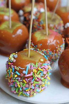 caramel apples with sprinkles and candy on a white plate, ready to be eaten