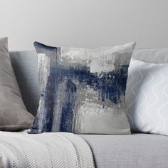 a couch with some pillows on it next to a white and gray wall, which has been painted in different shades of blue