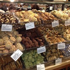 many different kinds of doughnuts on display in a store