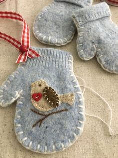 three handmade mittens, one with a bird and the other with a heart