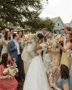 a bride and groom are surrounded by their wedding party