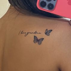 the back of a woman's shoulder with two butterflies on it, and an inscription in cursive writing