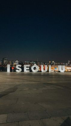 the sign is lit up at night in front of a large cityscape that reads i sequi