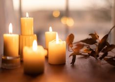 several lit candles sitting on top of a wooden table