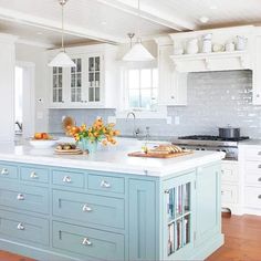 a kitchen with white cabinets and green island