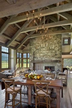 a rustic dining room with stone fireplace and wood flooring