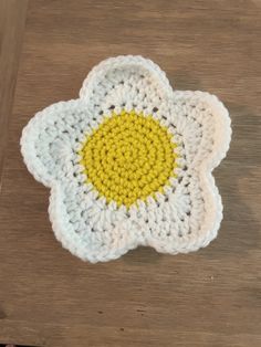 a crocheted flower on a wooden table