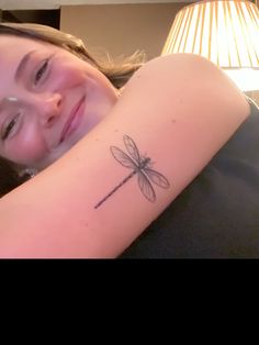 a girl with a dragonfly tattoo on her arm