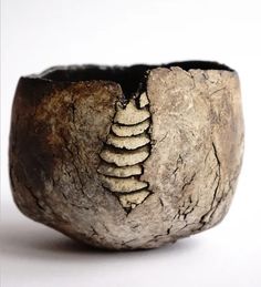 a close up of a wooden bowl on a white surface with cracks in the wood