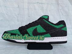 a green and black nike dunkin's sweet 16 sneaker on a stand