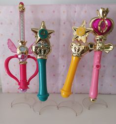 three different colored toothbrushes with gold stars on them, one pink and one blue