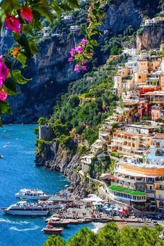 boats are parked on the water near some buildings and cliffs in positi, italy