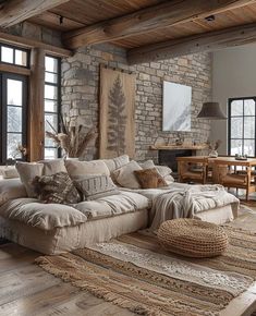 a living room filled with lots of furniture next to large windows on top of a wooden floor