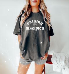 "♥ Looking for the perfect blend of comfort & style? Add one of our trendy Comfort color tees to your wardrobe! This design features a \"Raising Disciples\" graphic, perfect for the Christian mama wanting to display her faith! This design can also be purchased in a cozy sweatshirt option here! https://etsy.me/3SrbEpr ♥ About Printing/Garment: All of our apparel is printed using DTG printing in which the design is printed directly onto the garment which reduces cracking and peeling over time when cared for properly. Graphics are NOT vinyl. :) This shirt is a high-quality Comfort Color garment-dyed tee that comes in a variety of gorgeous hues for a lived-in vintage look. It is made of 100% cotton with a heavyweight feel for durability, but an unmatched softness for comfort! Comfort color gar San Jose, Raising Disciples, Faith Tees, Christian Tshirt, Comfort Colors Shirt, Comfort Colors Tee, Dtg Printing, Comfort Color, Cozy Sweatshirts