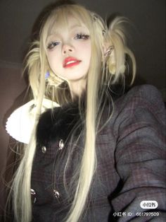 a woman with long blonde hair wearing a black jacket and red lipstick is posing for the camera