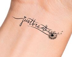 a tattoo on the wrist that says just breathe and dandelions are flying in the air