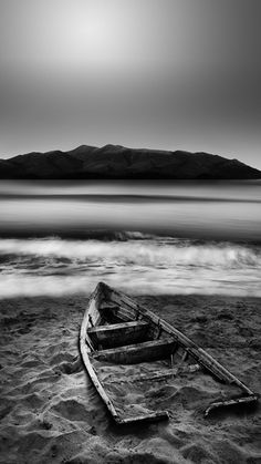 a boat sitting on top of a sandy beach