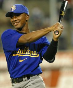 a baseball player is getting ready to hit the ball with his bat and smiling at the camera