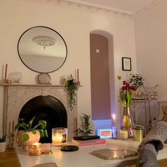 a living room filled with furniture and a fire place next to a mirror on the wall