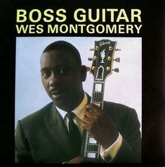 a man in a suit and tie holding a guitar with the words boss guitar west montgomery on it