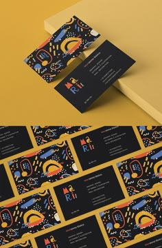 some business cards are stacked on top of each other, with different designs and colors