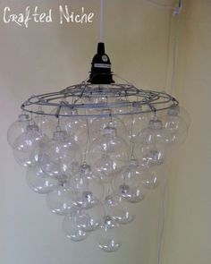 a chandelier hanging from the ceiling in a room with white walls and flooring