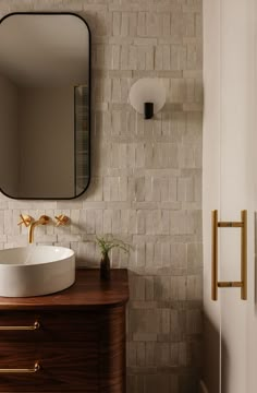 a bathroom sink sitting under a mirror on top of a wooden counter next to a door