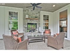 a living room filled with furniture and a fire place in the middle of an open floor plan