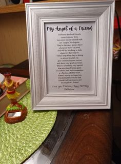 a framed poem is sitting on a table next to a figurine and books